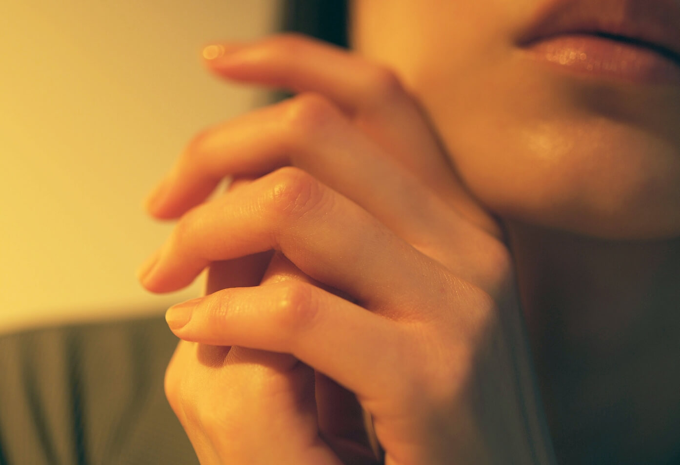 顔の近くに添えられた手元のアップ。繊維の肌触りと自分を慈しむ時間を表現