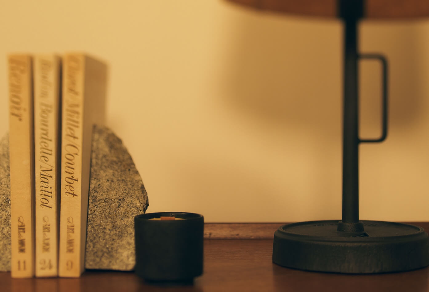 本とキャンドルが並ぶ、静かな夜のくらしのイメージ