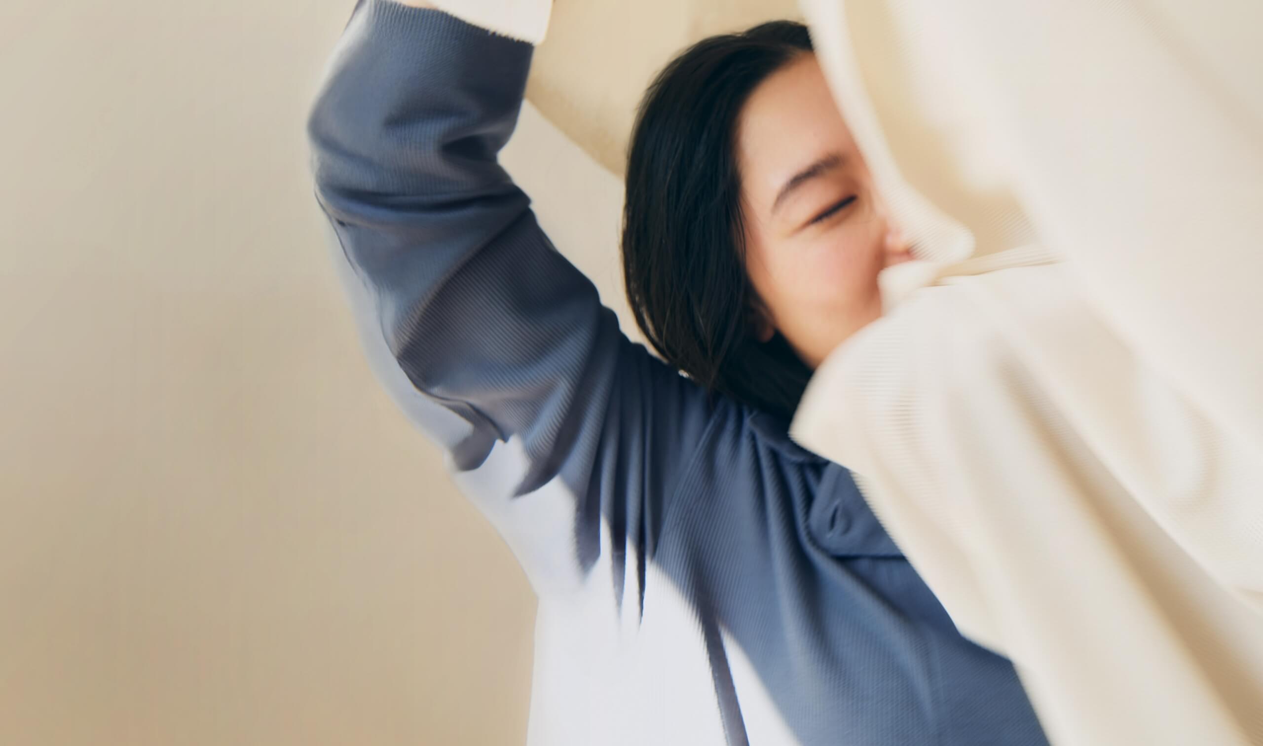 心地よい繊維に包まれる女性。Fibers for well-being（繊維でより良い人生を）を象徴するイメージ