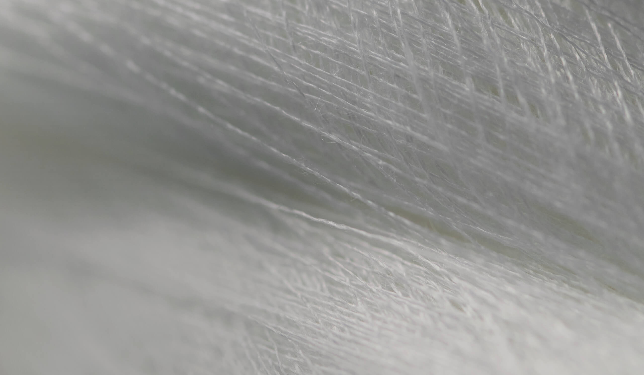 肌に触れる繊維の質感を強調したアップ。健やかな「からだ」を支える機能性のイメージ